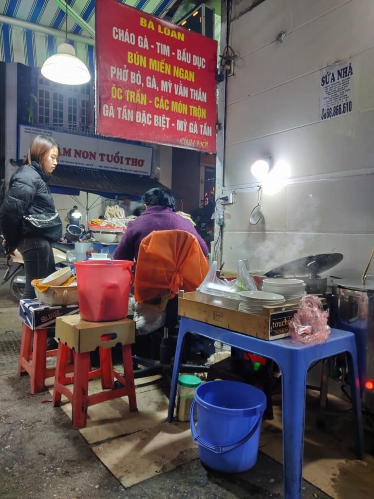 Photographie d'un restaurant de rue (street food) de pho dans une ruelle à Hanoi, au Vietnam