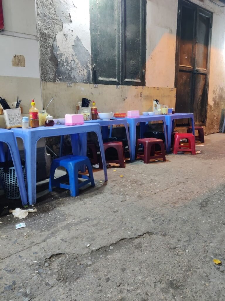 Photographie d'un restaurant de rue (street food) de pho dans une ruelle à Hanoi, au Vietnam